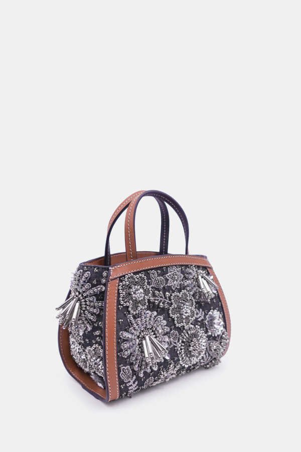 Designer silver clutch bag with denim shell, gold hardware, and embroidery