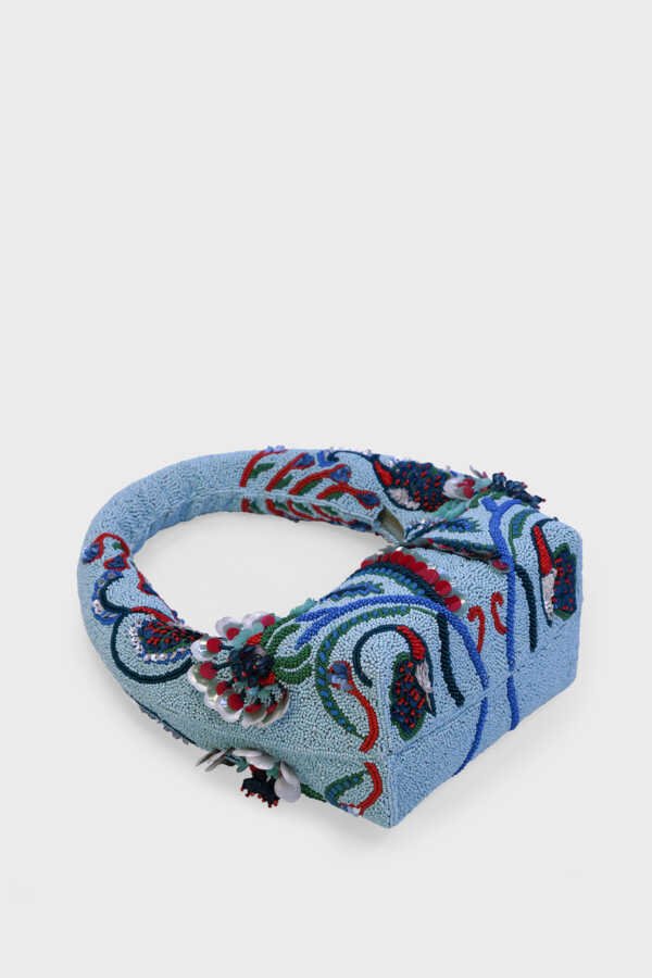 Detailed shot of turquoise, emerald, and red bead embroidery